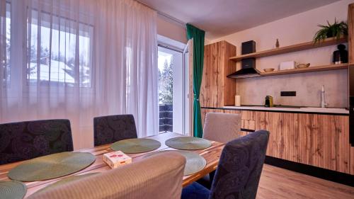 a dining room with a table and chairs and a window at Family TreeZ Premium Apartments in Poiana Brasov