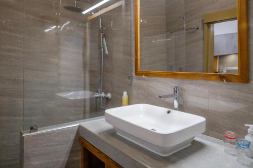 a bathroom with a white sink and a shower at Grand Large - cosy studio in Papeete