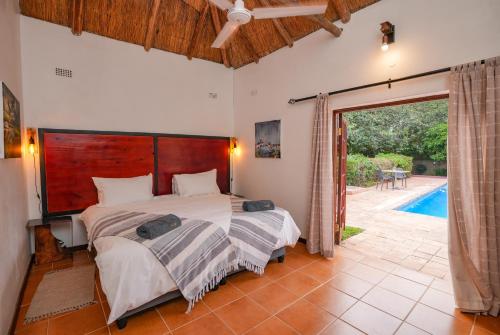 1 dormitorio con 1 cama grande y puerta corredera de cristal en The Little Outlook en Victoria Falls