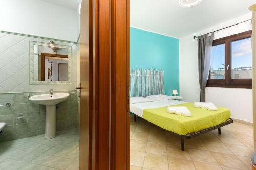 una camera da letto con un letto e un bagno con un lavandino di I Tre Golfi - Appartamenti con Terrazzo fino a 800 mt dal mare a San Vito lo Capo