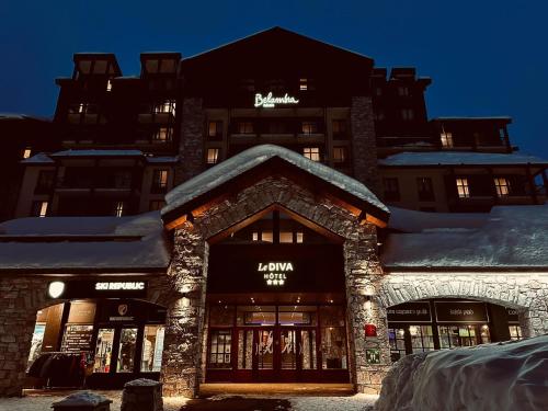 ein Geschäft vor einem Gebäude mit Schnee auf dem Dach in der Unterkunft Hôtel Tignes Le Diva in Tignes