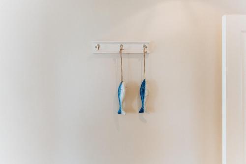 two blue umbrellas hanging on a white wall at Sterretjie in Paternoster