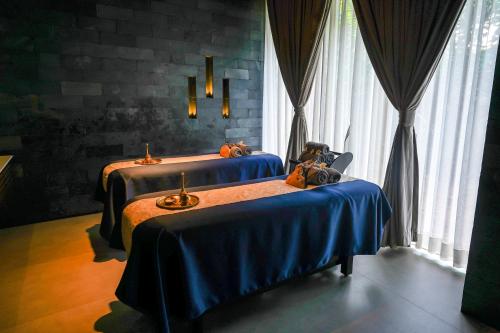 two beds in a room with blue sheets at Radisson Resort and Spa Lonavala in Lonavala