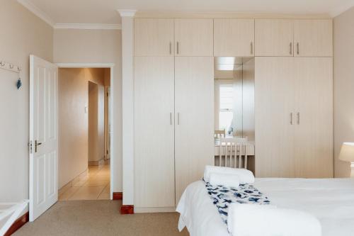 a bedroom with white cabinets and a bed at Sterretjie in Paternoster