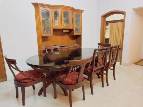 uma sala de jantar com uma mesa de madeira e cadeiras em Dream Palace em Alappuzha