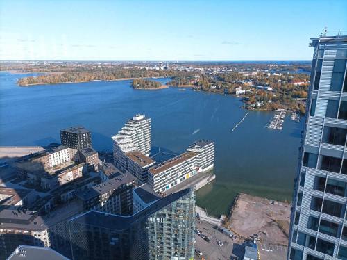 uma vista aérea de uma cidade com um rio e edifícios em Modern skyscraper apartment by metro and sea Helsinki em Helsinque