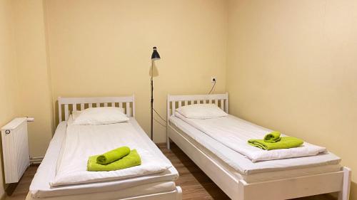two beds in a room with green towels on them at Kastanimaja Apartments in Tartu