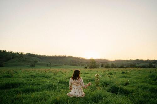 a woman sitting in a field of grass at Whisky @ On The Rocks in Rock Valley