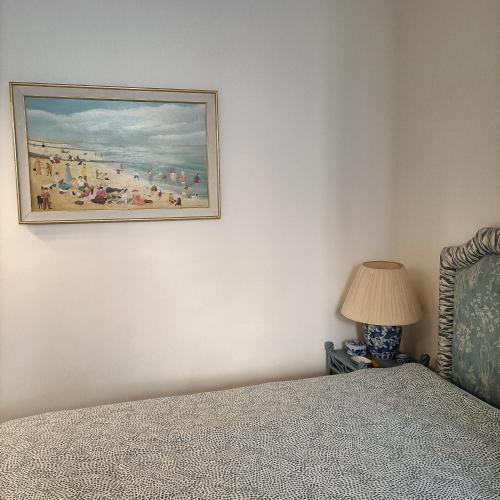 a bedroom with a painting of a beach at ILE SAINT LOUIS 2 CHAMMBRES 2 SALLE DE BAINS PARKING in Paris