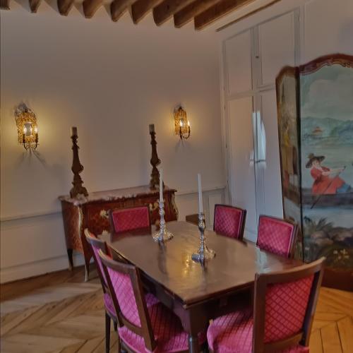 a dining room with a table with pink chairs at ILE SAINT LOUIS 2 CHAMMBRES 2 SALLE DE BAINS PARKING in Paris
