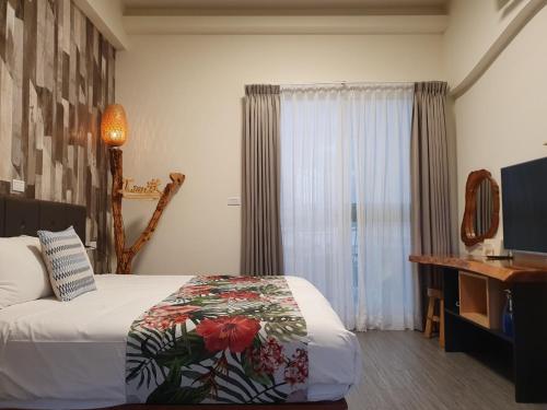 a bedroom with a bed and a desk and a window at Inn巷文創旅店 Inn siang B&B-墾丁夢幻島 in Sigou