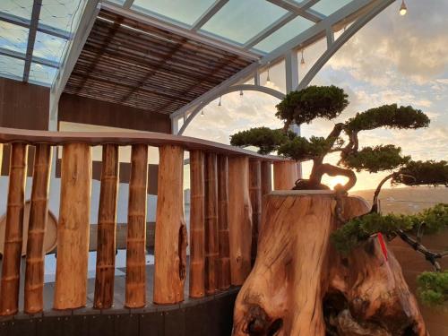 a bonsai tree sitting on a wooden balcony at Inn巷文創旅店 Inn siang B&B-墾丁夢幻島 in Sigou