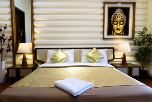 バンガロールにあるSwiss Royal Suitesの壁に金色のマスクが飾られた大きなベッドのある寝室