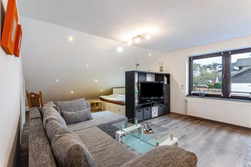 a living room with a couch and a television at Lydias Ferienwohnung in Schmallenberg
