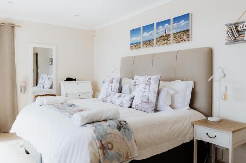a bedroom with a large white bed with pillows at Sterretjie in Paternoster