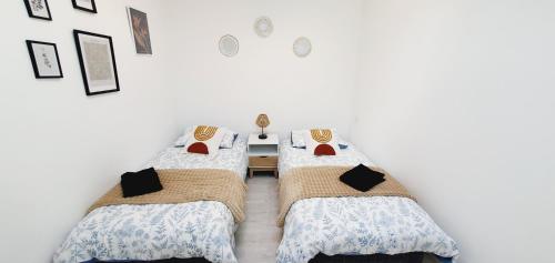 2 Betten in einem Zimmer mit weißen Wänden in der Unterkunft Le Delambre in Perpignan