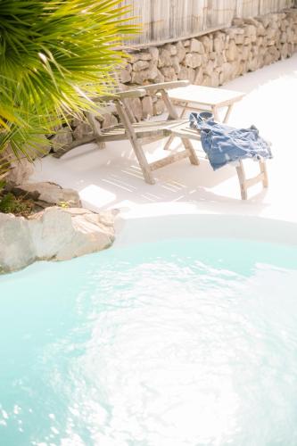 a chair sitting next to a pool of water at PAVI APARTMENTS Life Style House with private pool in Kornić