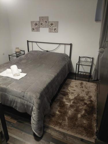 a bedroom with a bed with a blanket and a rug at Simbas House in Leonidion