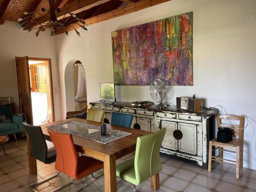 a kitchen with a table and a painting on the wall at Divas Gartenhaus in Vasilítsion