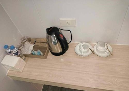 a counter with a tea kettle and shoes on it at Venice Star Grand Hotel in Manila