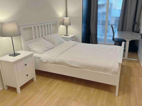 1 dormitorio con 1 cama blanca con 2 lámparas y piano en Downtown Apartment, en Kavala