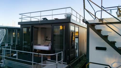 a balcony of a boat with a room on it at Luxurious waterloft near beach and centre by Weltevreden Experience in Zeewolde