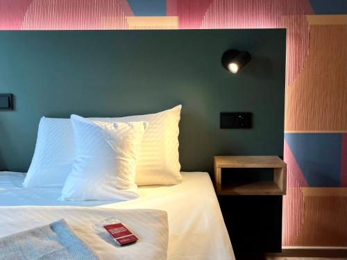 a bedroom with a bed with a red book on it at Kloster-Quartier in Münster