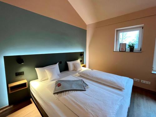 a bedroom with a large white bed with a window at Kloster-Quartier in Münster