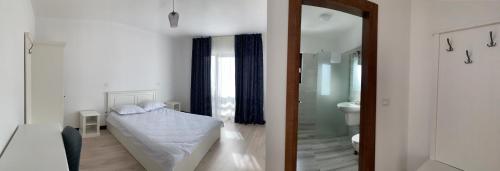 a white room with a bed and a bathroom at Hotel Dia Lin in Borşa
