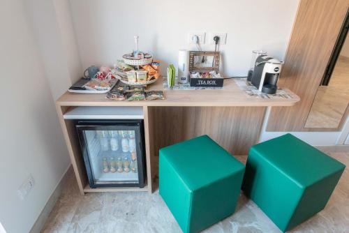 two green stools in front of a small refrigerator at B&B Il Risveglio del Cavaliere in Gioia dei Marsi