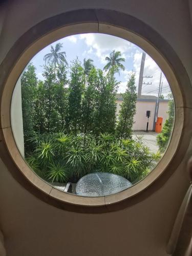 a round window with a view of a garden at NST Boutique เอ็นเอสทีบูทีค in Ban Pak Phun