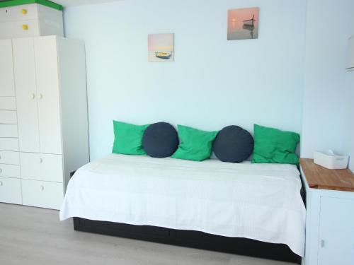 a white bedroom with a bed with green pillows at Estudio Roses, estudio, 4 personas - ES-228-112 in Roses