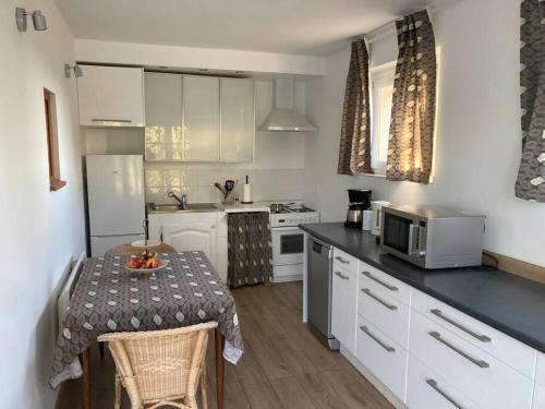 a small kitchen with a table and a microwave at Gîte au milieux des oliviers. in Caromb