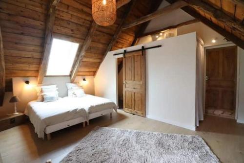 a bedroom with a white bed and a large window at Gîte du Milan royal in Le Monteil