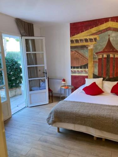 a bedroom with a bed with red pillows on it at Gîte au milieux des oliviers. in Caromb
