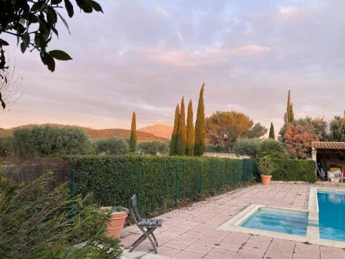 une piscine dans un jardin avec une clôture et des arbres dans l'établissement Gîte au milieux des oliviers., à Caromb