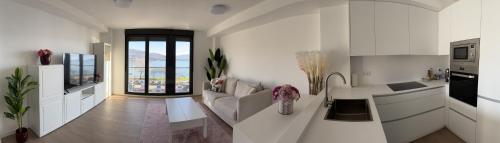 cocina blanca con sofá y encimera en El Mirador Ría de Vigo, apartamento frente al mar, céntrico, en Moaña