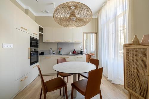 une cuisine avec une table et des chaises dans une cuisine dans l'établissement LE WINDSOR confortable pour un séjour au calme en centre-ville, à Cannes