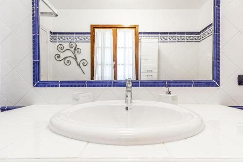 La salle de bains blanche est pourvue d'un lavabo et d'un miroir. dans l'établissement Exclusive Roth Apartments, à Sassari