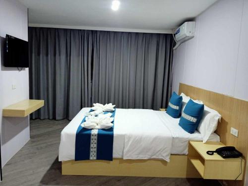 a bedroom with a large bed with blue and white pillows at Venice Star Grand Hotel in Manila