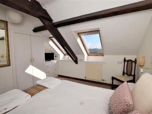 um quarto com uma cama e uma janela em 2 Bed in Conwy TYCAN em Llangelynin