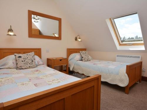 a bedroom with two beds and a mirror and a window at 2 Bed in Bamburgh 36338 in East Ord