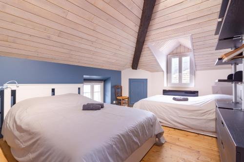 two beds in a room with blue walls and wooden ceilings at La Polaire - 3 chambres télécabine à 200m in Ax-les-Thermes