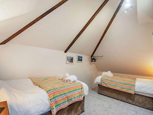 2 Bed in North Tawton 40336 في نورث تاوتن: سريرين في غرفة بجدران بيضاء