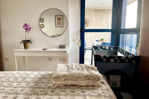Schlafzimmer mit einem Bett, einem Tisch und einem Spiegel in der Unterkunft Apto con vistas a la playa de La Patacona in Valencia