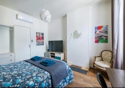 a bedroom with a bed and a flat screen tv at New York in Montargis