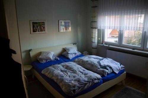 two unmade beds in a bedroom with a window at Kernberg Apartment Jena in Jena