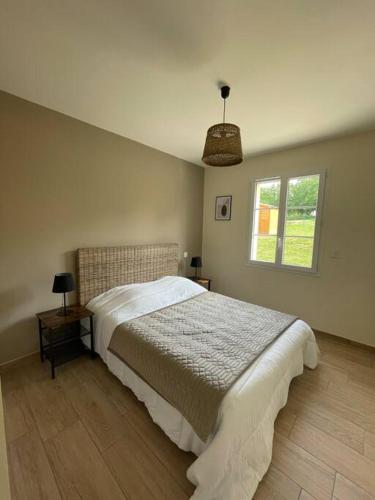 une chambre avec un grand lit et une fenêtre dans l'établissement Les Pins*Calme*Confort*Piscine, à Sarlat-la-Canéda