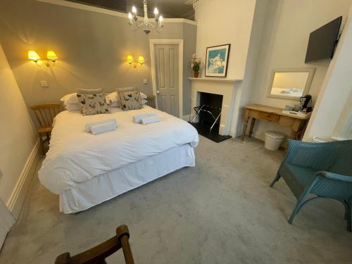 a bedroom with a large white bed and a fireplace at Poplars Farm in Henlow