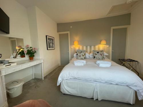 a bedroom with a large white bed with two pillows at Poplars Farm in Henlow